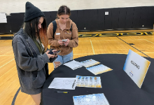 Two teenage girls standing at a table