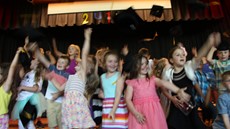 Kindergarten students throwing their graduation caps in the air