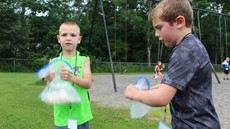 Two young boys shaking plastic bags