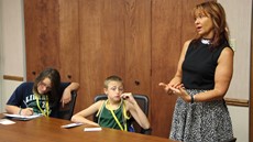 Two children listening to speaker in conference room