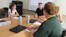 Students at conference table talking to Chad Smith