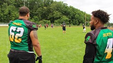 Two football players looking out onto a field