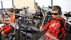 Five children drumming on drum sets