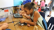 Child looking at a robot on a desk