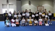 Group picture of cheer camp students, volunteers and coaches on gym mat