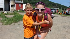 Older sister hugging her younger brother posing for a picture