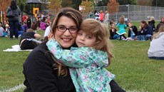 Young girl hugging her mother with both looking at the camera