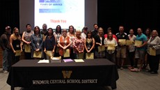 Picture of service award winners in front of stage