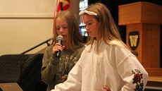 Hannah Tracy and Marissa Strawn speaking at the front of the auditorium