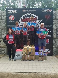 Four people in BMX racing gear on a podium