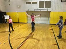 On child jumping in the air with two others holding a jump rope