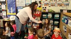 A woman standing with students sitting in a classroom