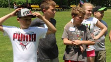 Five children standing in a line outside in a park