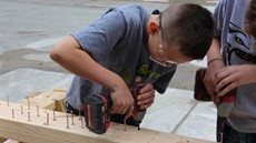 A child drilling screws into a board