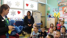 A woman sitting in front of a classroom of pre-k student