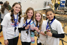 Four girls wearing medals