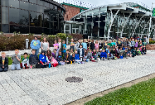 dozens of children in front of a building