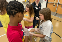 A girl holding a bandage on a boy