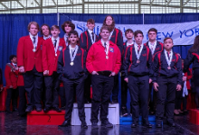 Group of teenagers in jackets and ties standing near a podium
