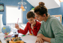 A woman and young boy sitting at a desk.