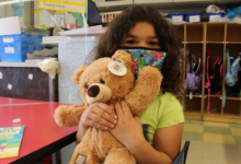 A little girl holding a teddy bear