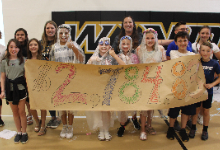 Kids and adults holding a banner with $2,784.83 written on it