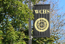 WCHS Black banner in front of a tree