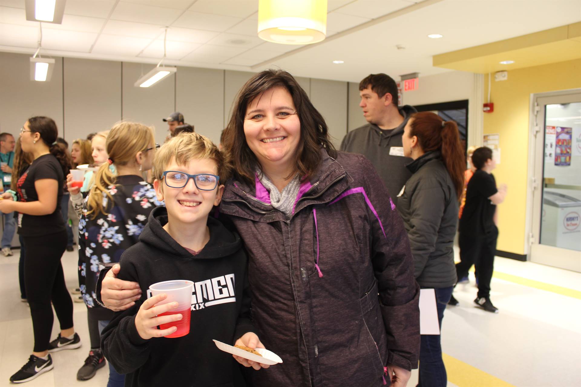 A woman standing with a young boy