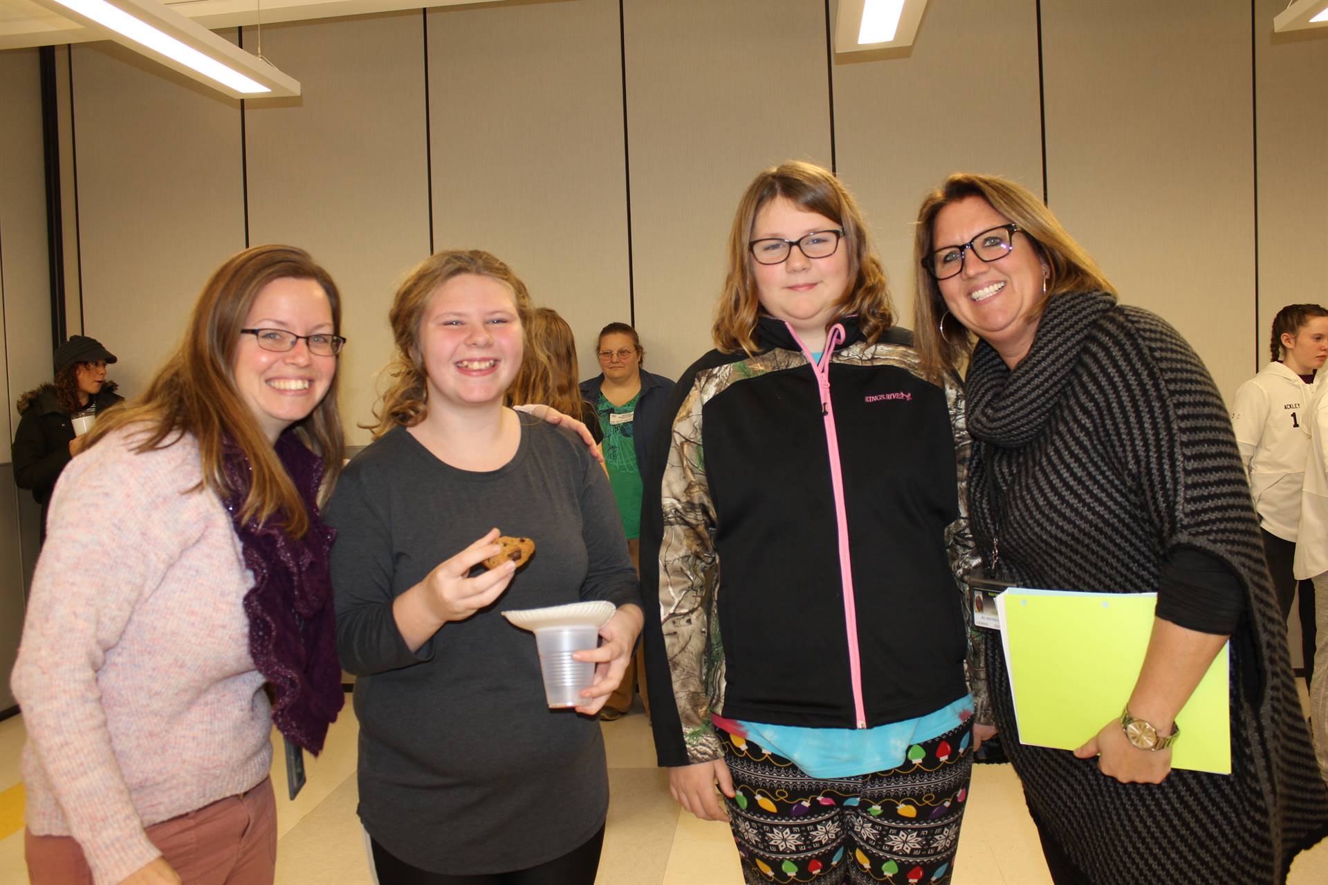 Two women standing with two girls smiling