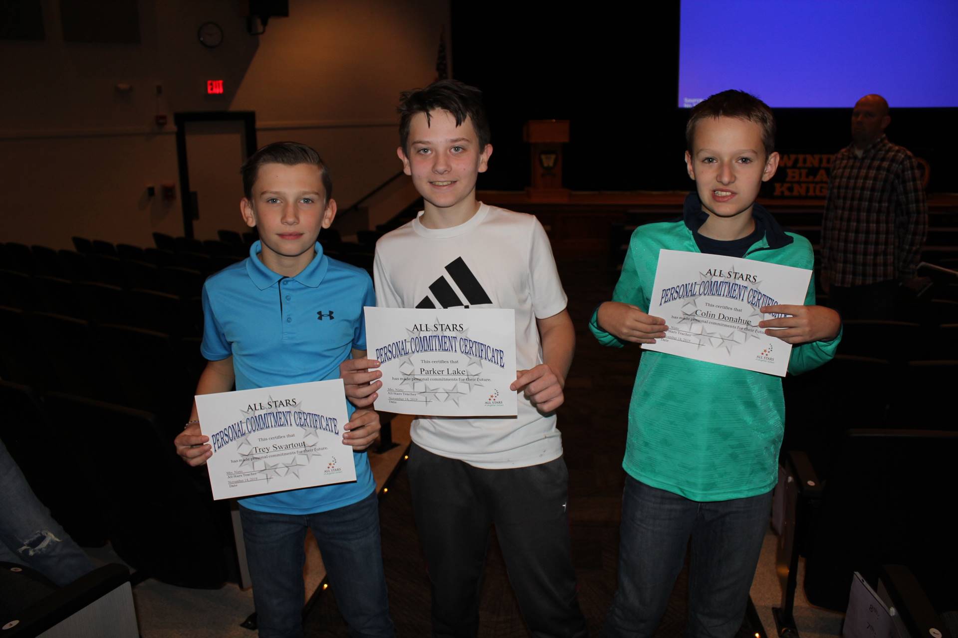 Three boys holding certificates