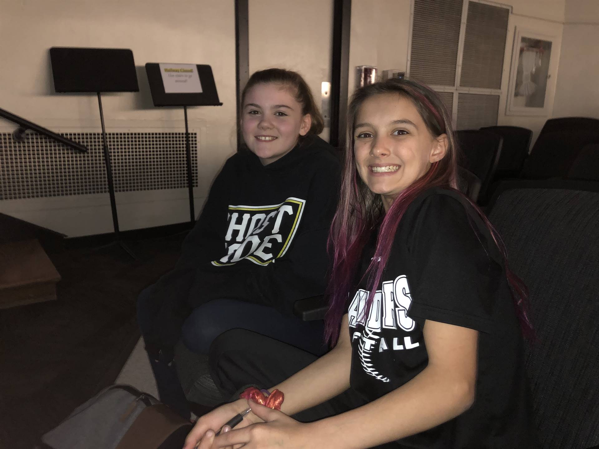 Two girls sitting in auditorium seats