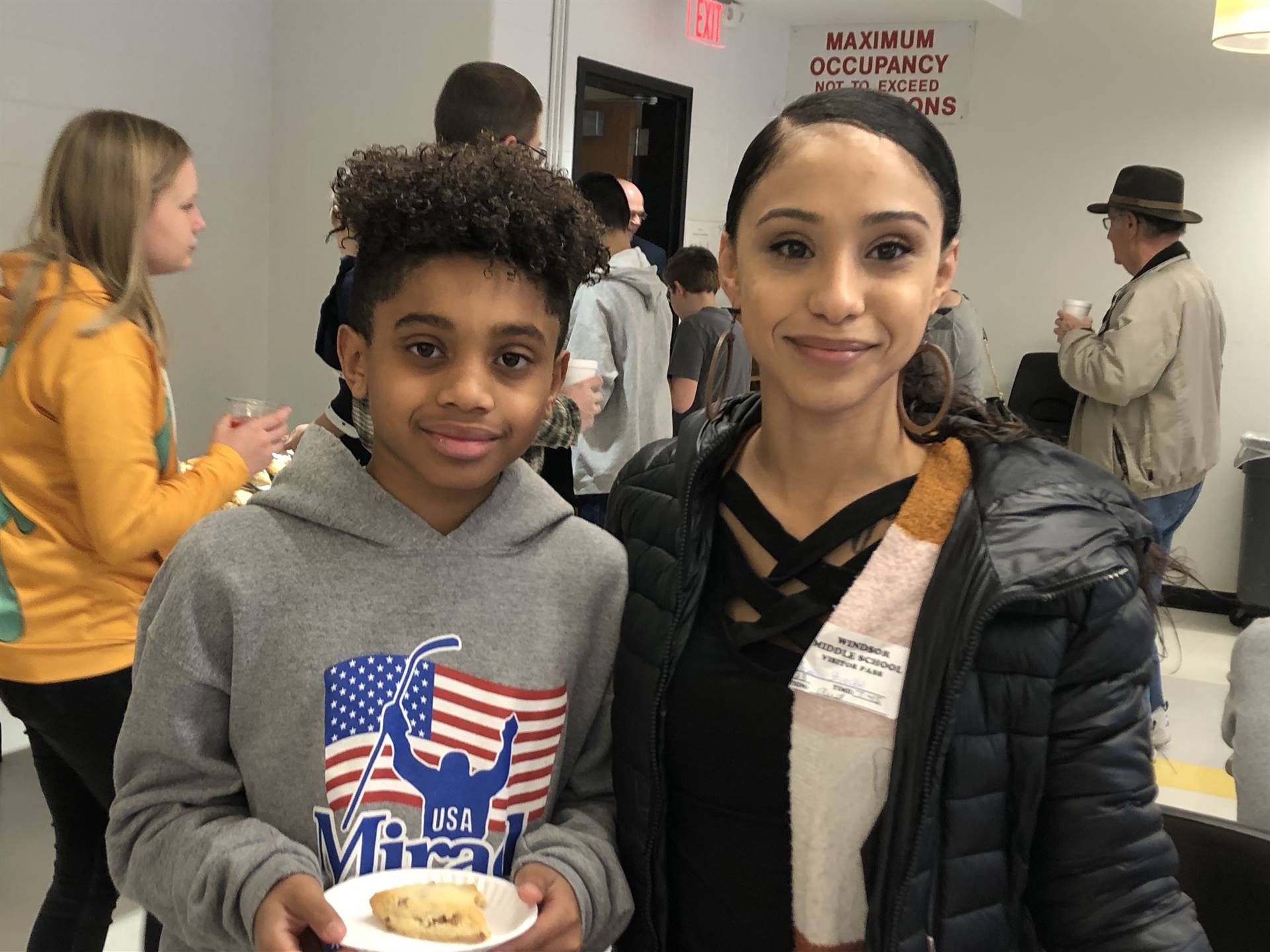 A woman standing next to a boy