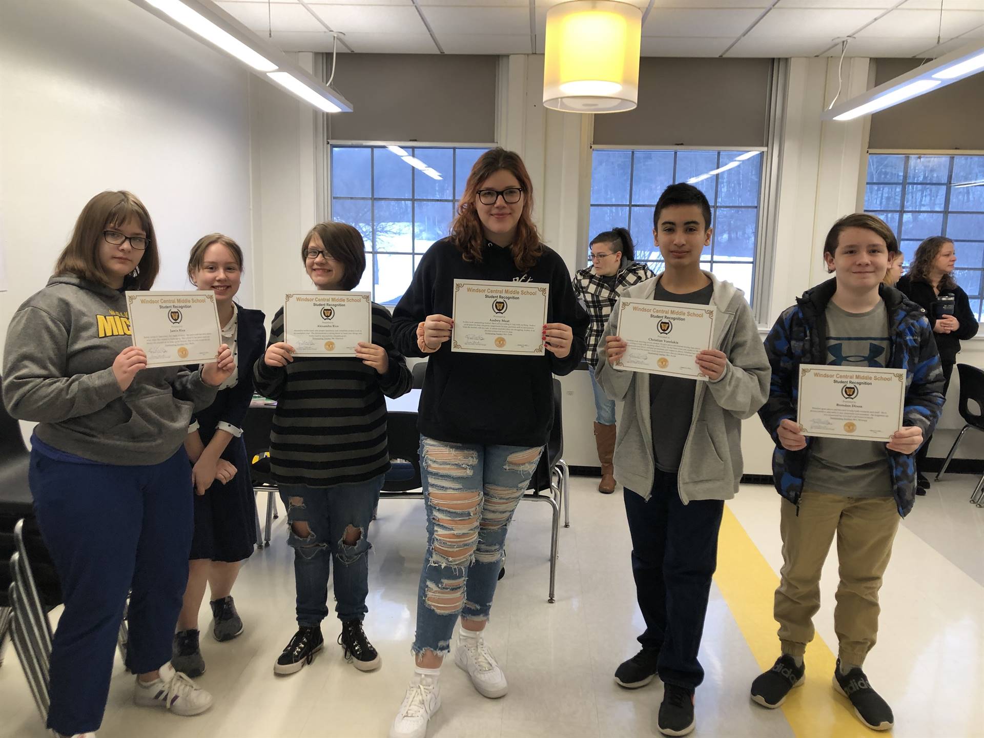 Six children standing, holding certificates