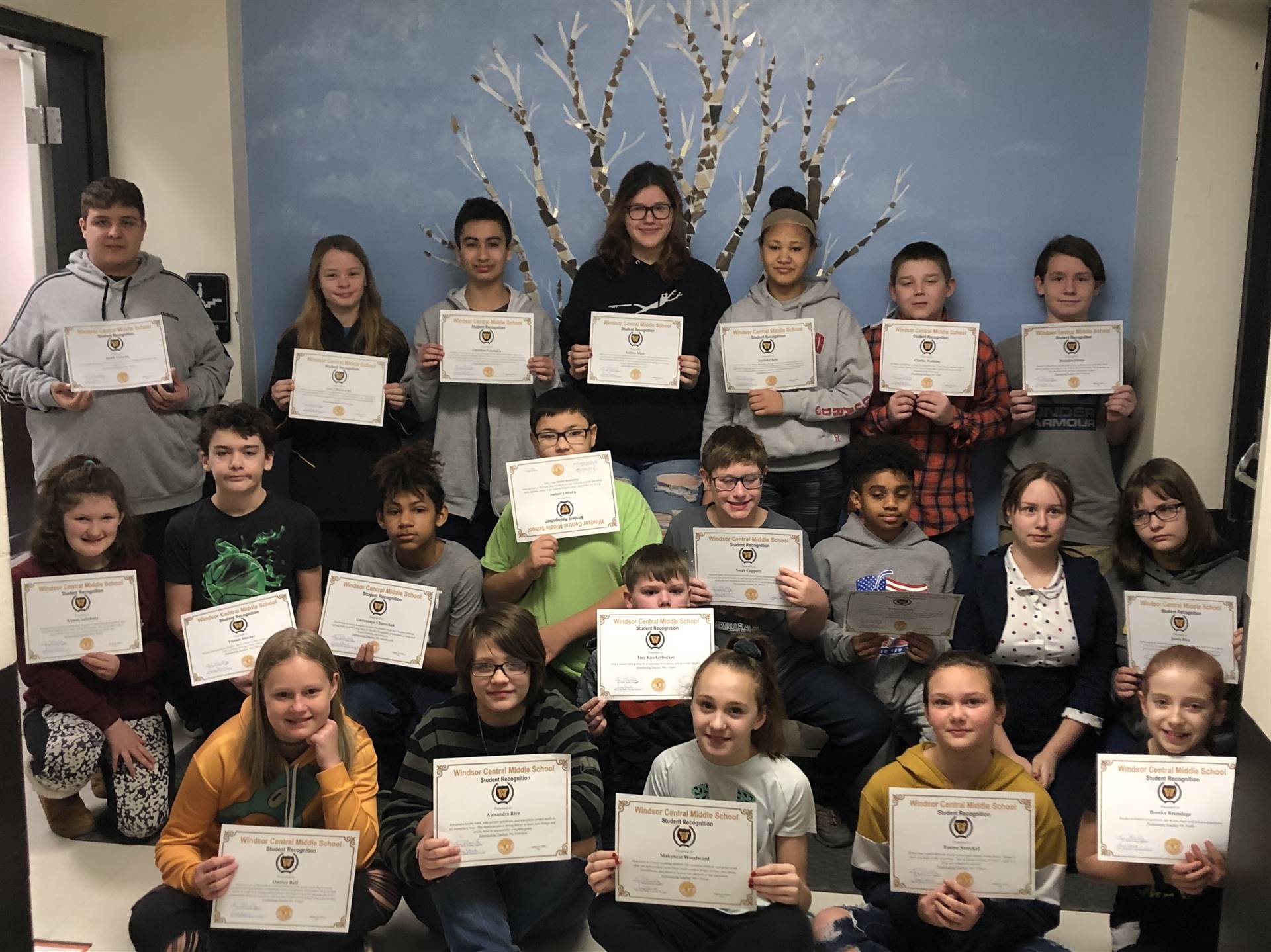 Three rows of children holding certificates
