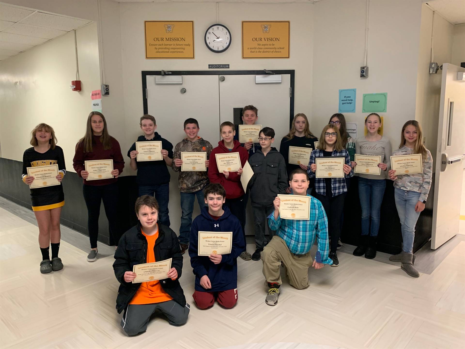 Two rows of young students holding certificates