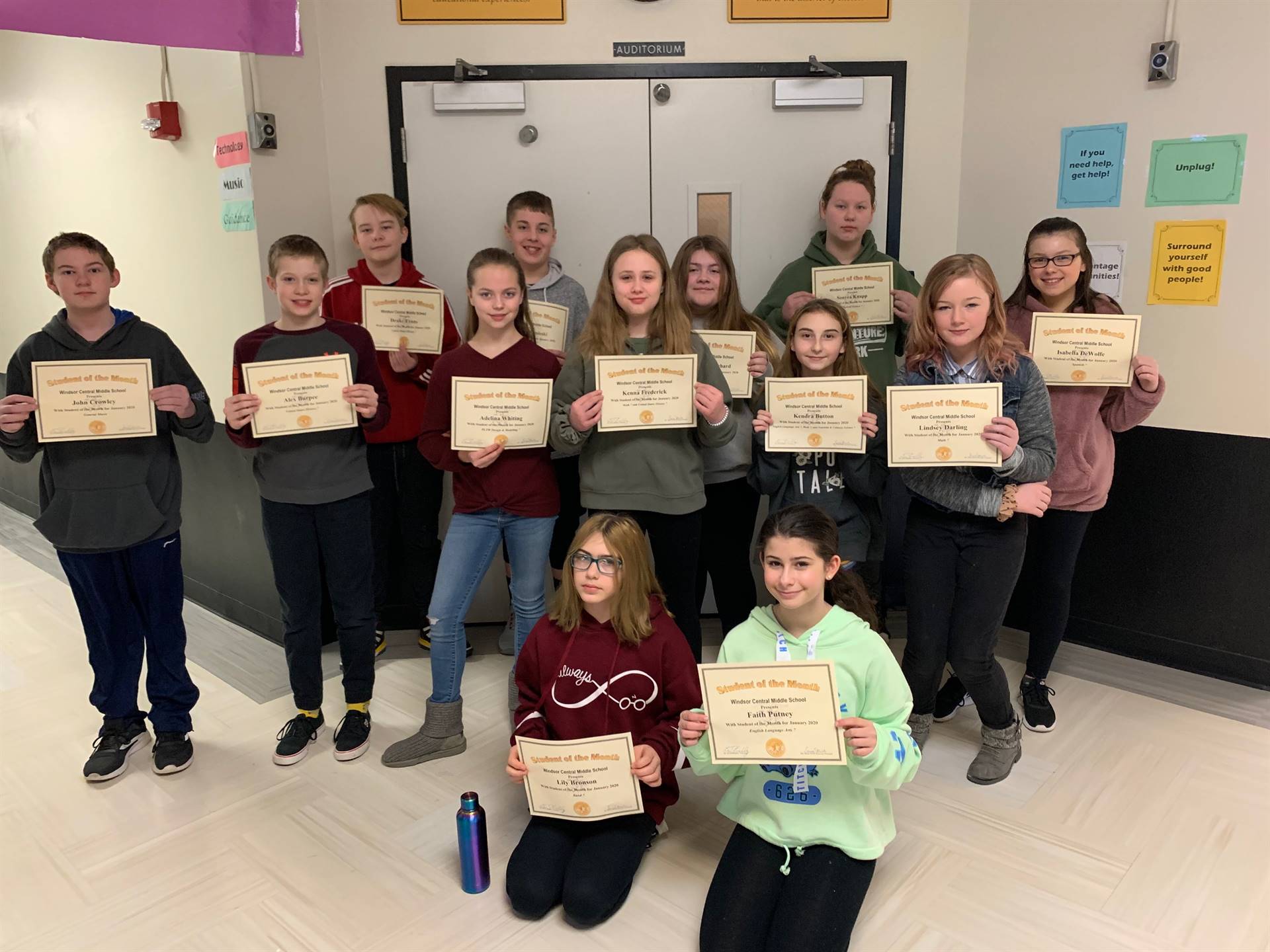 Three rows of 7th grade students holding certificates