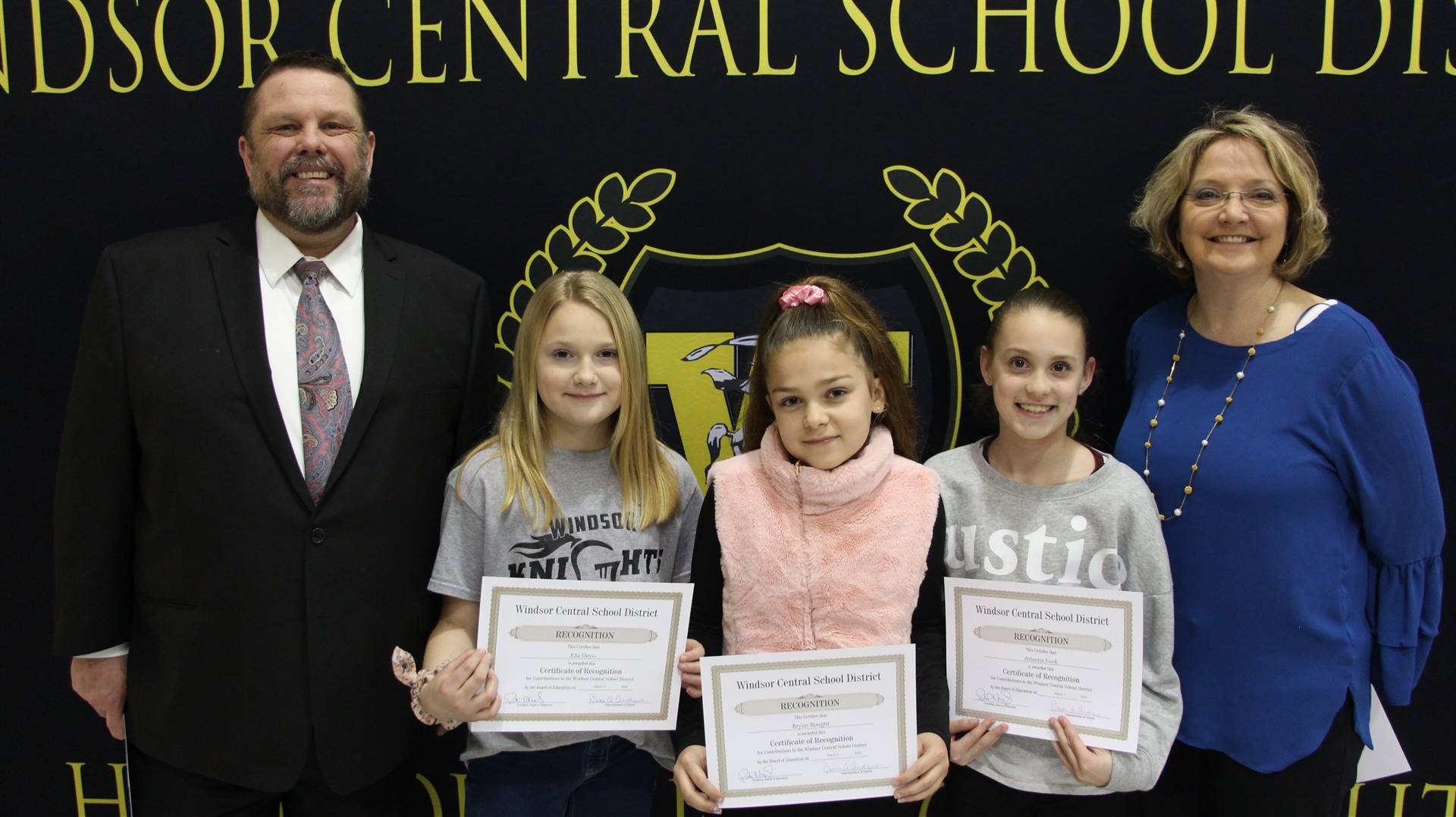 Three young girls standing between Pete Nowacki and Margo Kibbler