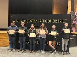 High school students in front of a banner